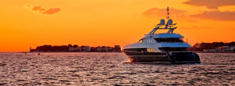 Yachtig on open sea at golden sunset panoramic view