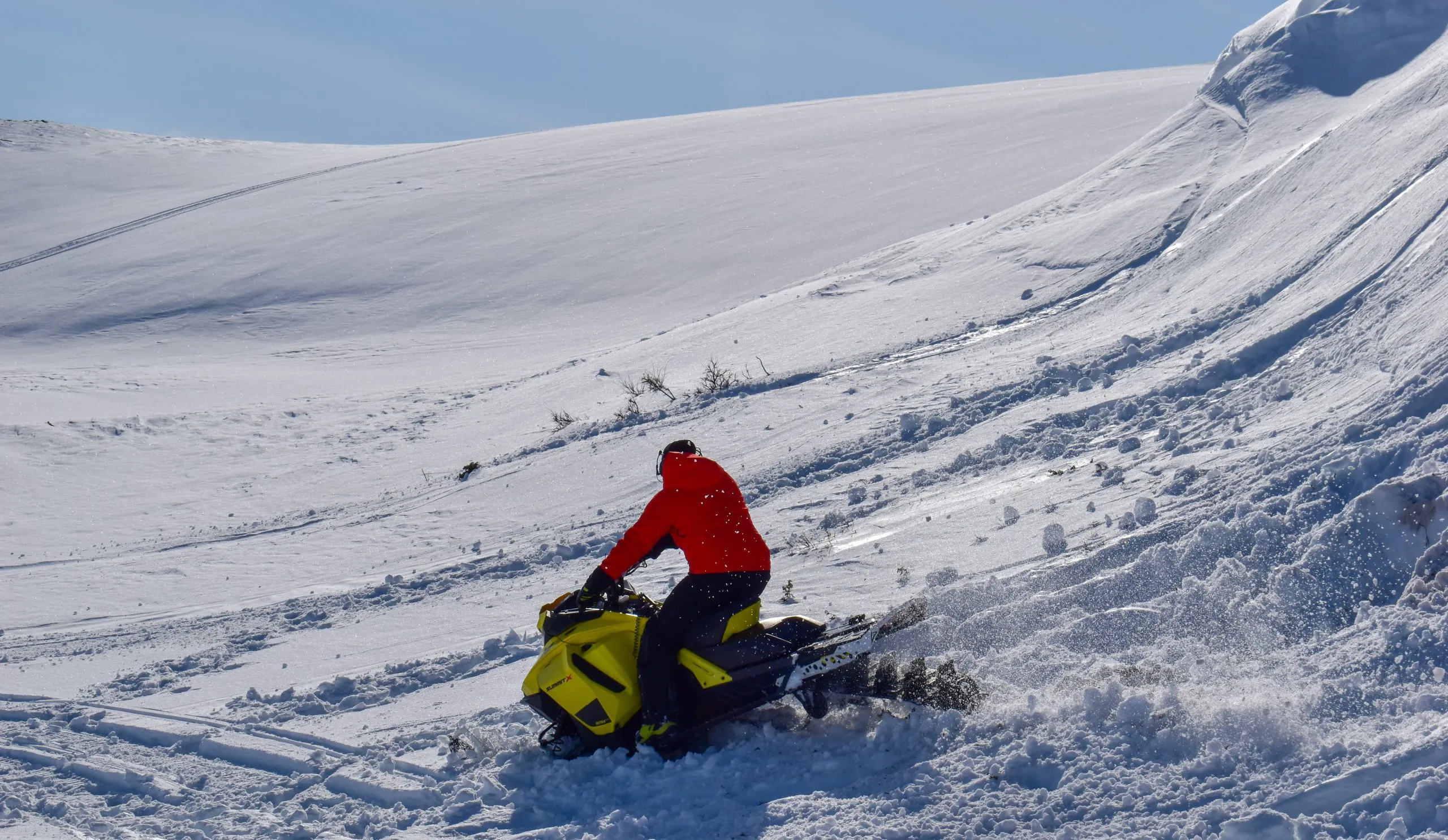 A man is riding snowmobile in mountains. Beautiful day in Swedish Lapland.